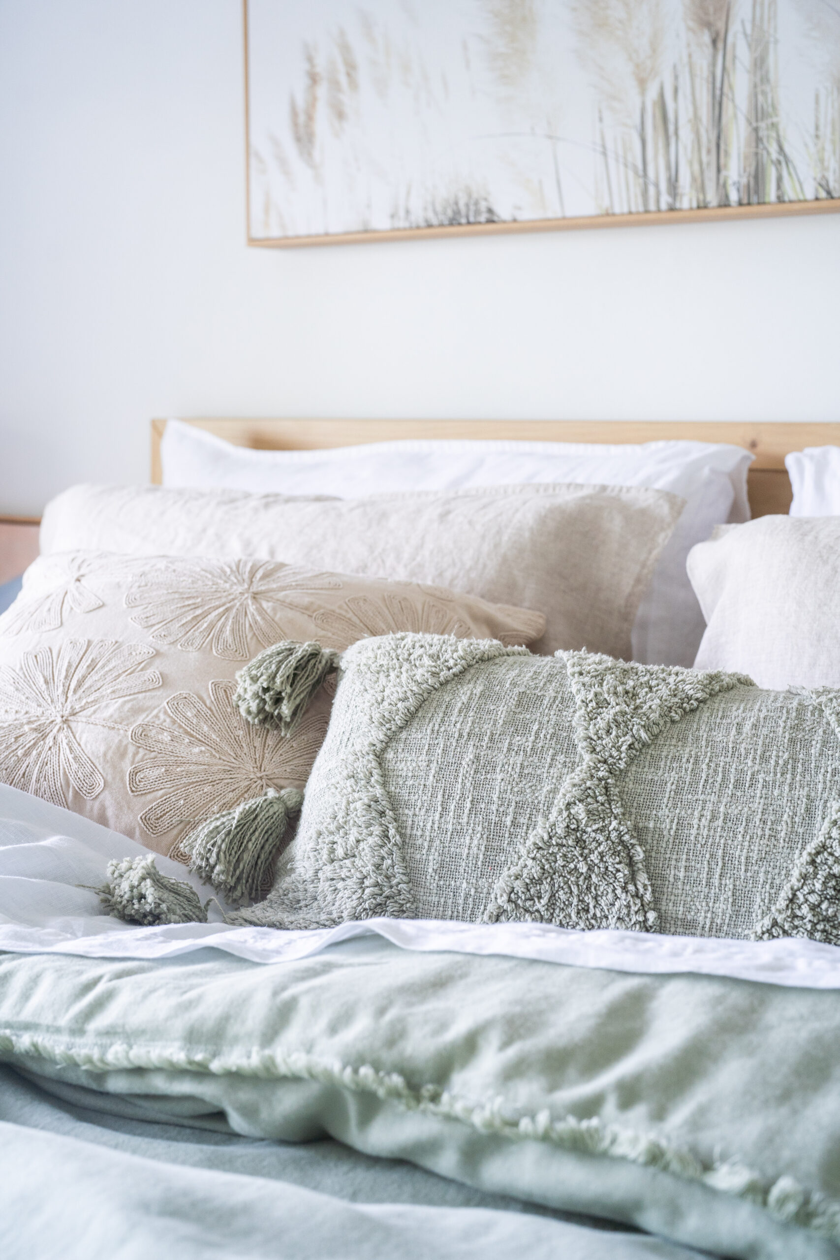 Layered linen bedding and textured cushions in soft neutral tones styled in a modern organic bedroom by a Melbourne interior designer, Lisa Hunter Interiors