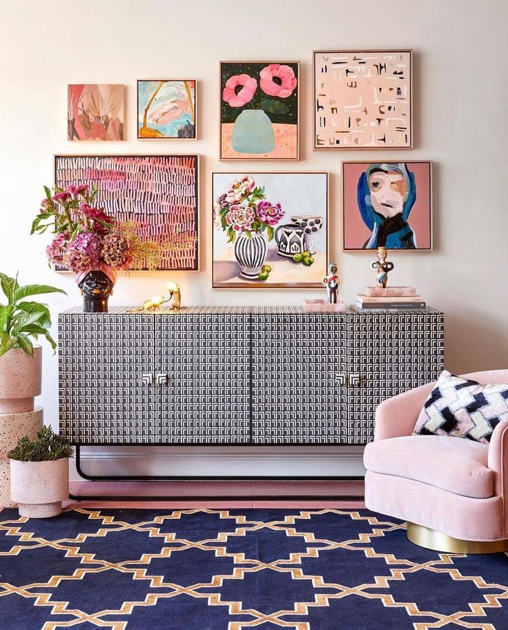 Colourful gallery wall arranged above a patterned sideboard featuring layered framed artwork, balanced spacing and coordinated styling in a contemporary interior.